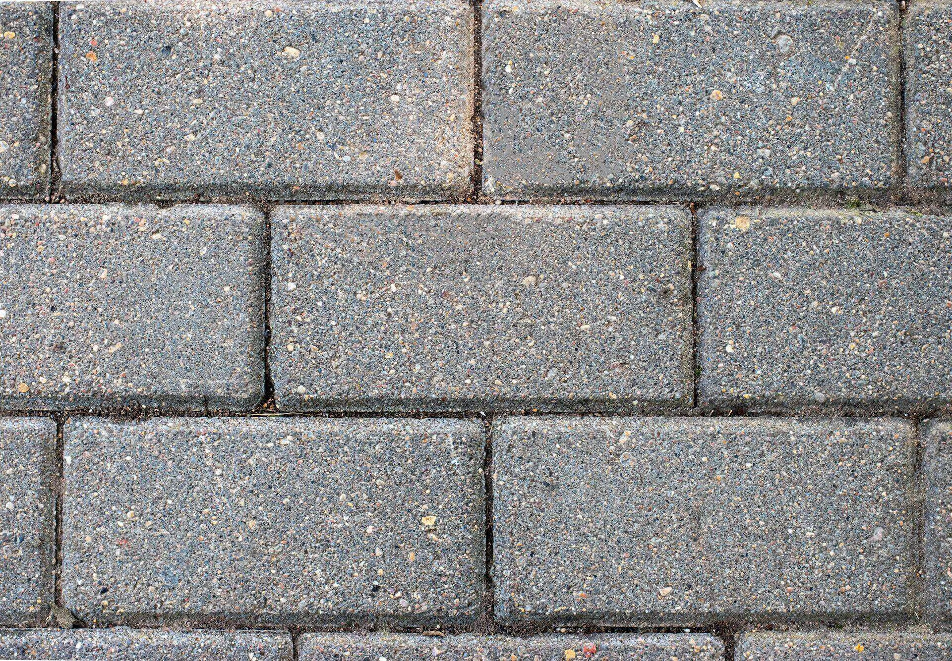Close-up view of a textured concrete block wall arranged in a staggered pattern.