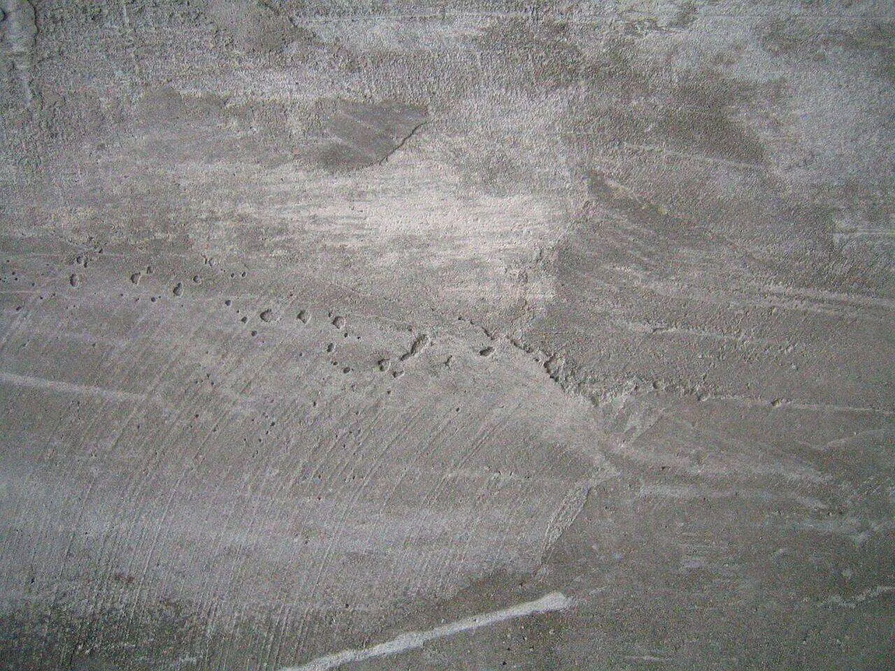 Close-up view of a rough concrete surface with visible texture and finishing marks.
