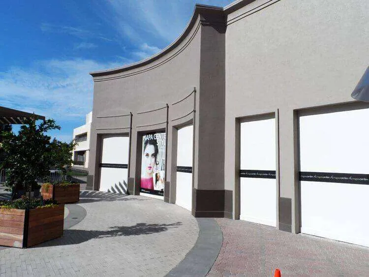 Commercial building with smooth EIFS finish and closed storefronts under a clear sky. — Napa area