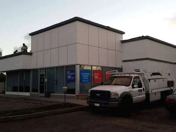Commercial building with modern plaster finish and work truck in front.