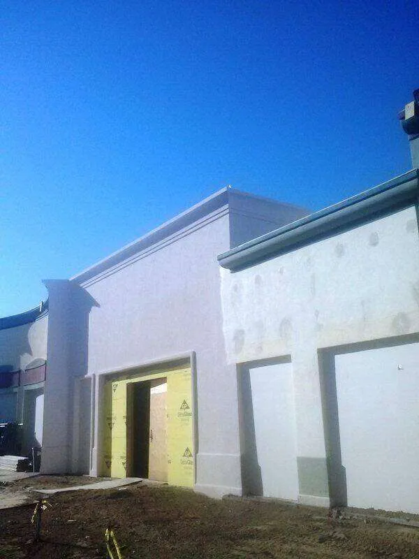 Commercial building with EIFS exterior under construction, showing insulation panels around entrance. — Sonoma area