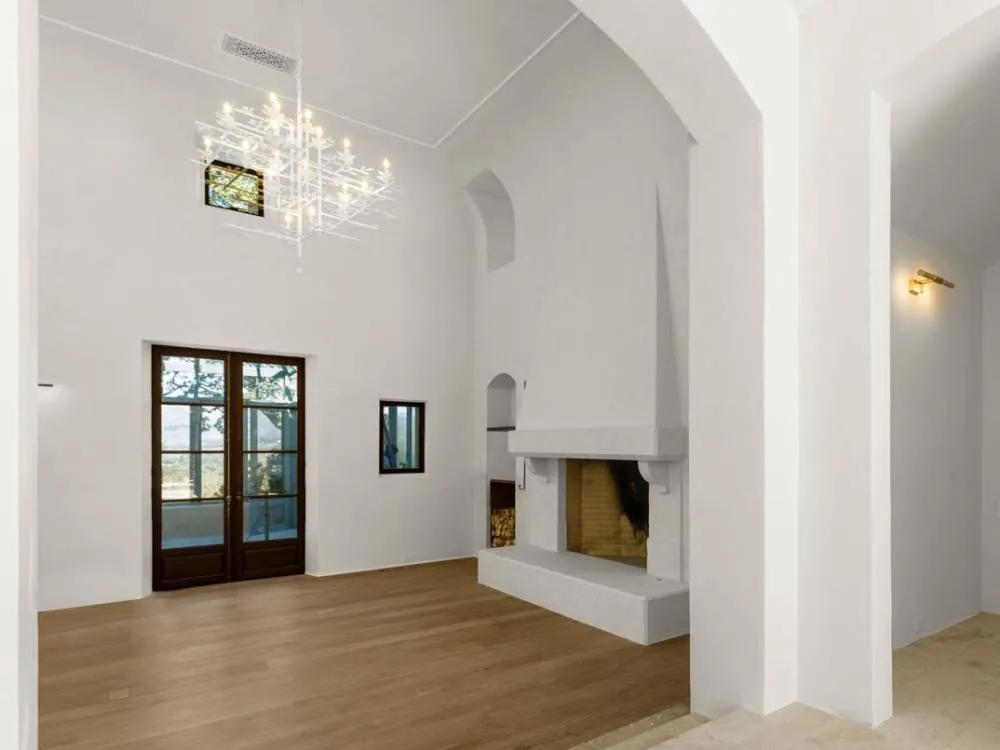 Spacious room with chandelier, fireplace, wooden floor, and French doors in Saint Helena. — Napa area