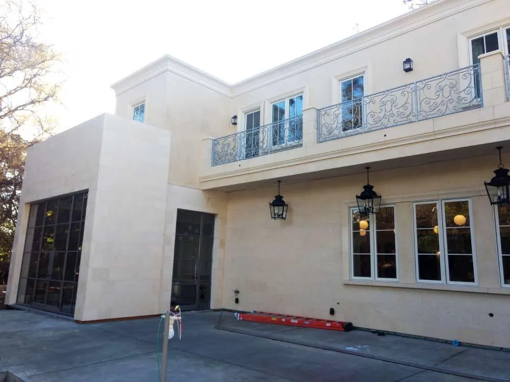 Two-story home with smooth stucco finish, large windows, and metal railings. — Hillsborough area