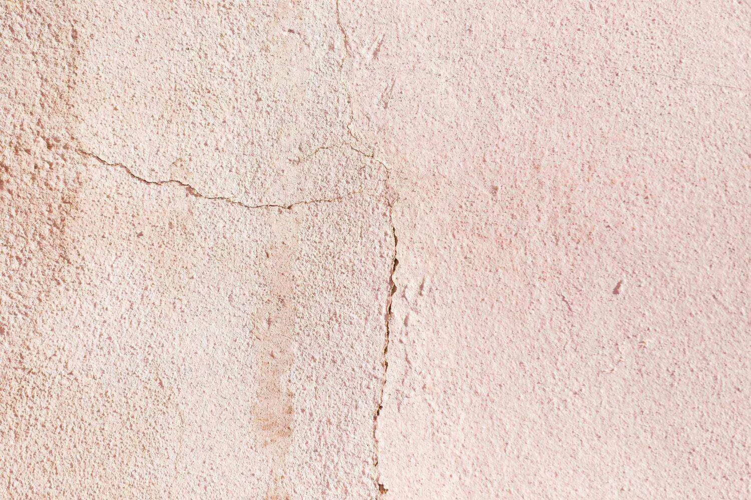 Close-up of a plaster wall with visible hairline cracks running horizontally and vertically. — Ross area