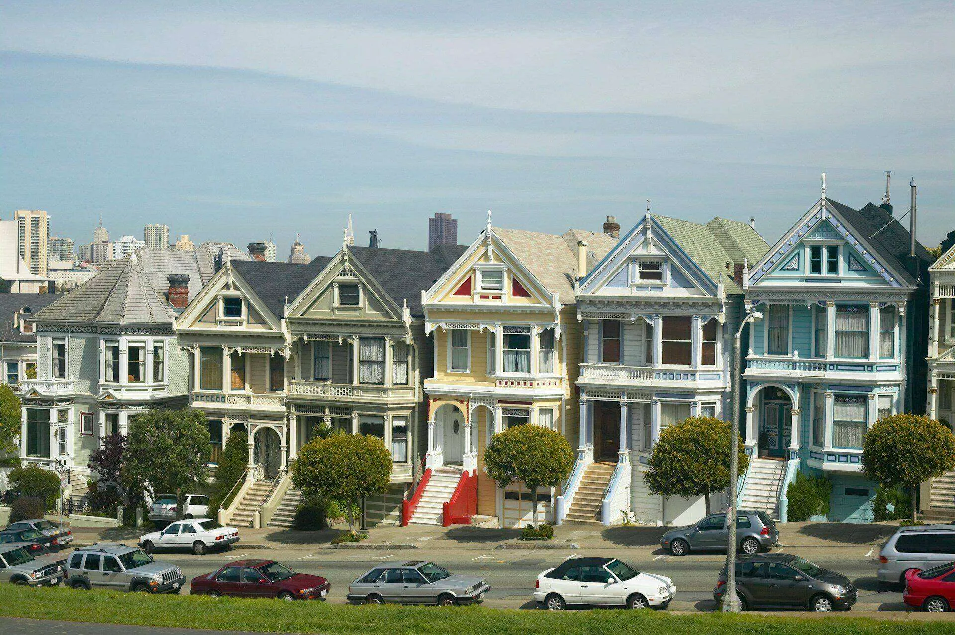 Row of colorful Victorian houses with city skyline in background, known as the Painted Ladies in San Francisco. — work near San Francisco