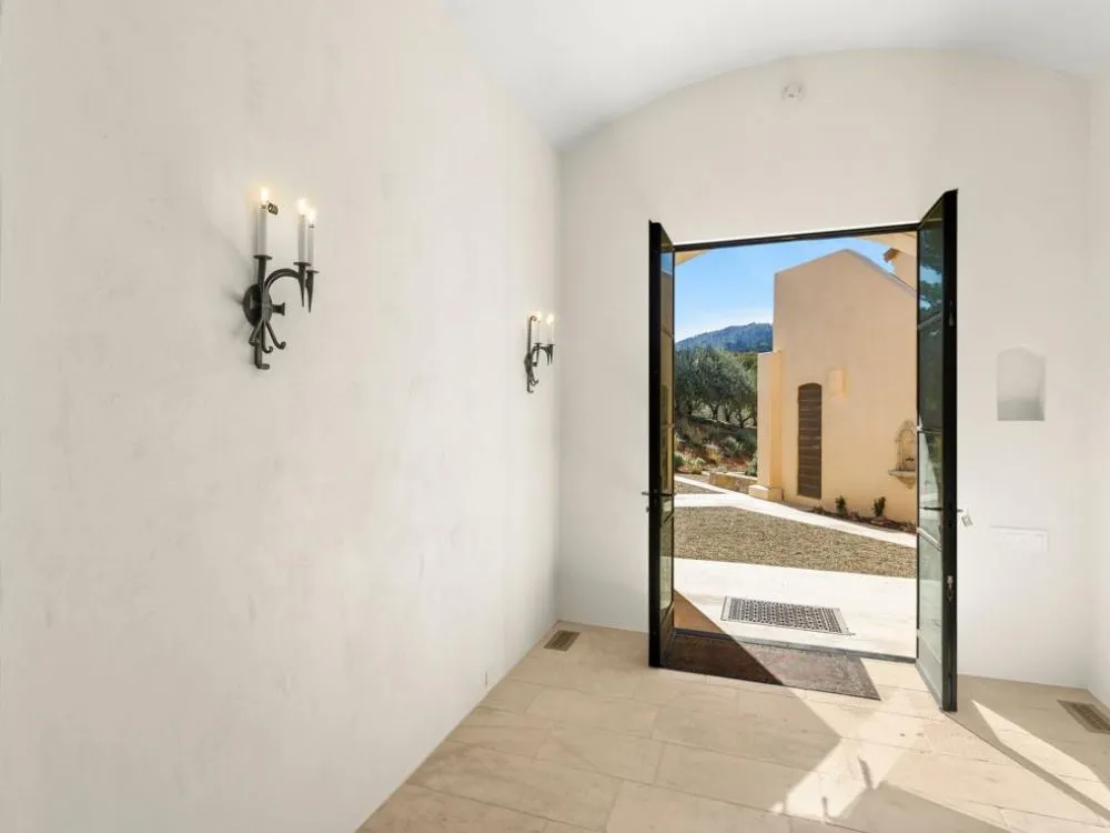 Interior room with plaster walls and open door to courtyard at Saint Helena.