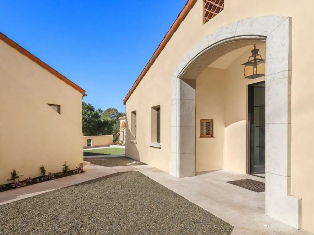Mediterranean-style building with stucco walls and stone archway under a blue sky. — St. Helena area
