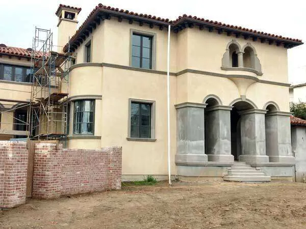 Mediterranean-style two-story home with stucco exterior and scaffolding on the side. — Kentfield area