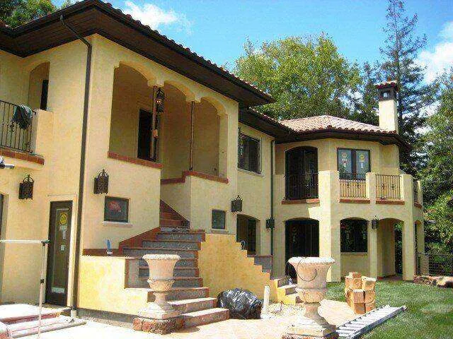 Mediterranean-style home with smooth stucco finish, arched entryways, and balconies. — Corte Madera area