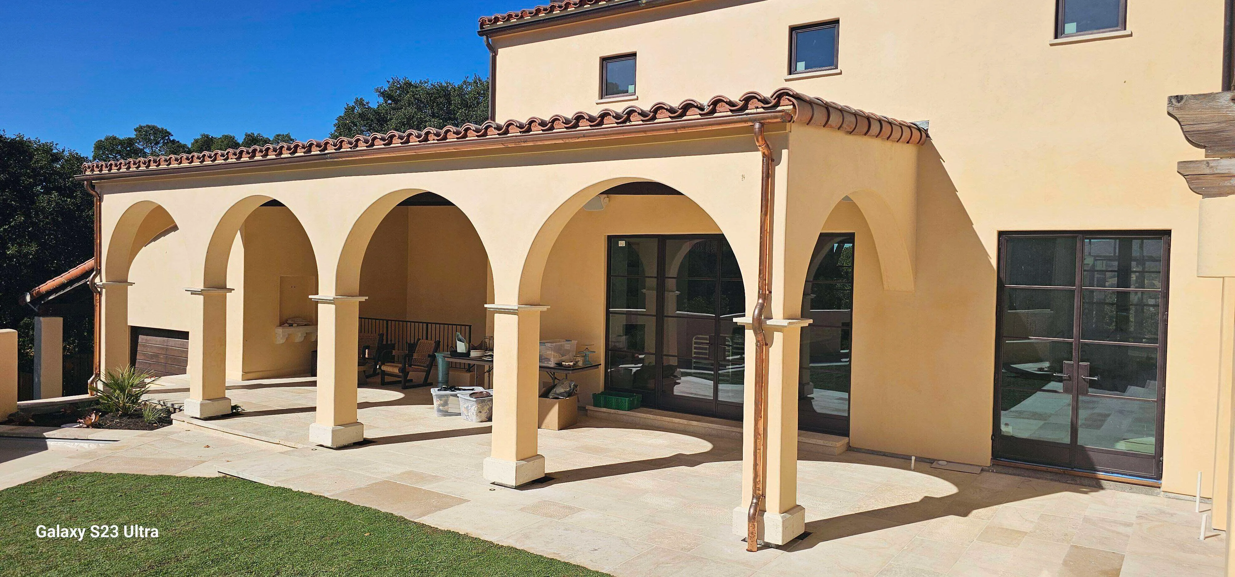 Mediterranean-style building with arches, smooth stucco, and tiled roof.