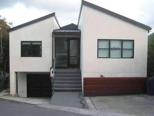 Modern residential home with smooth stucco finish, large windows, and central entrance. — St. Helena area