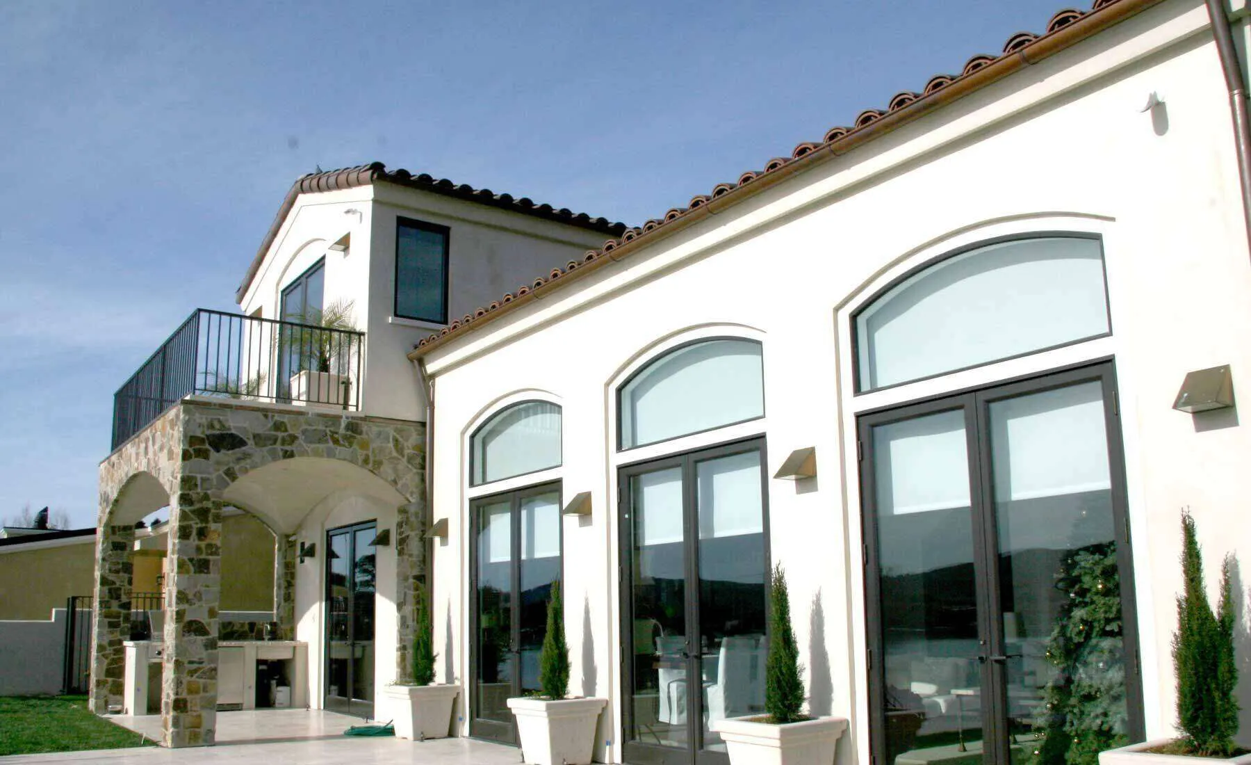 Modern two-story house with stucco exterior, stone accents, large windows, and balcony. — Corte Madera area