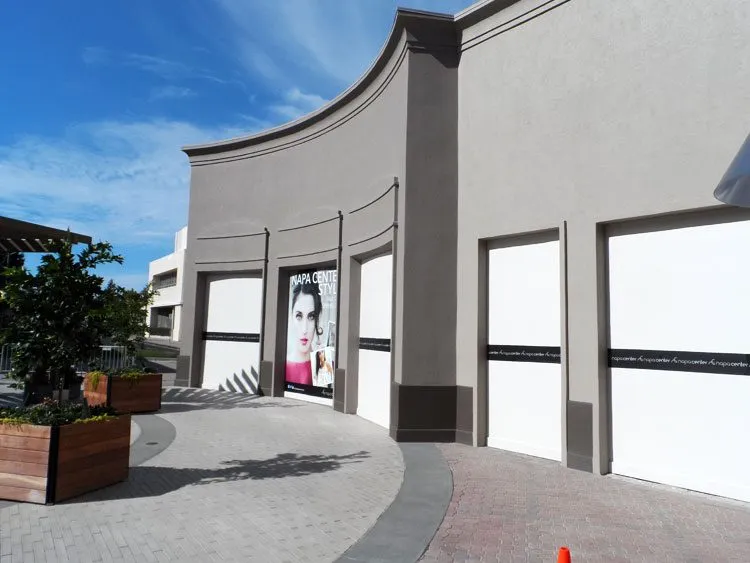 Commercial building with EIFS finish at Napa Town Center, featuring a smooth curved facade and a large poster.