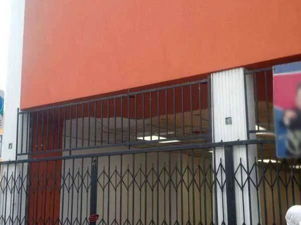 Commercial storefront in Oakland with orange EIFS stucco and metal security gates. — Sonoma area