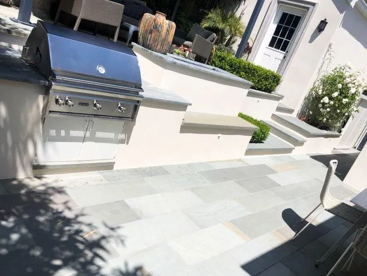 Outdoor patio with built-in grill, stone flooring, and garden steps in a residential setting. — El Cerrito area