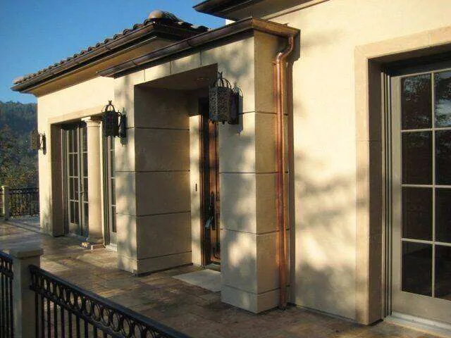Residential exterior with smooth stucco finish, large windows, and decorative lanterns on a patio. — work near Sausalito