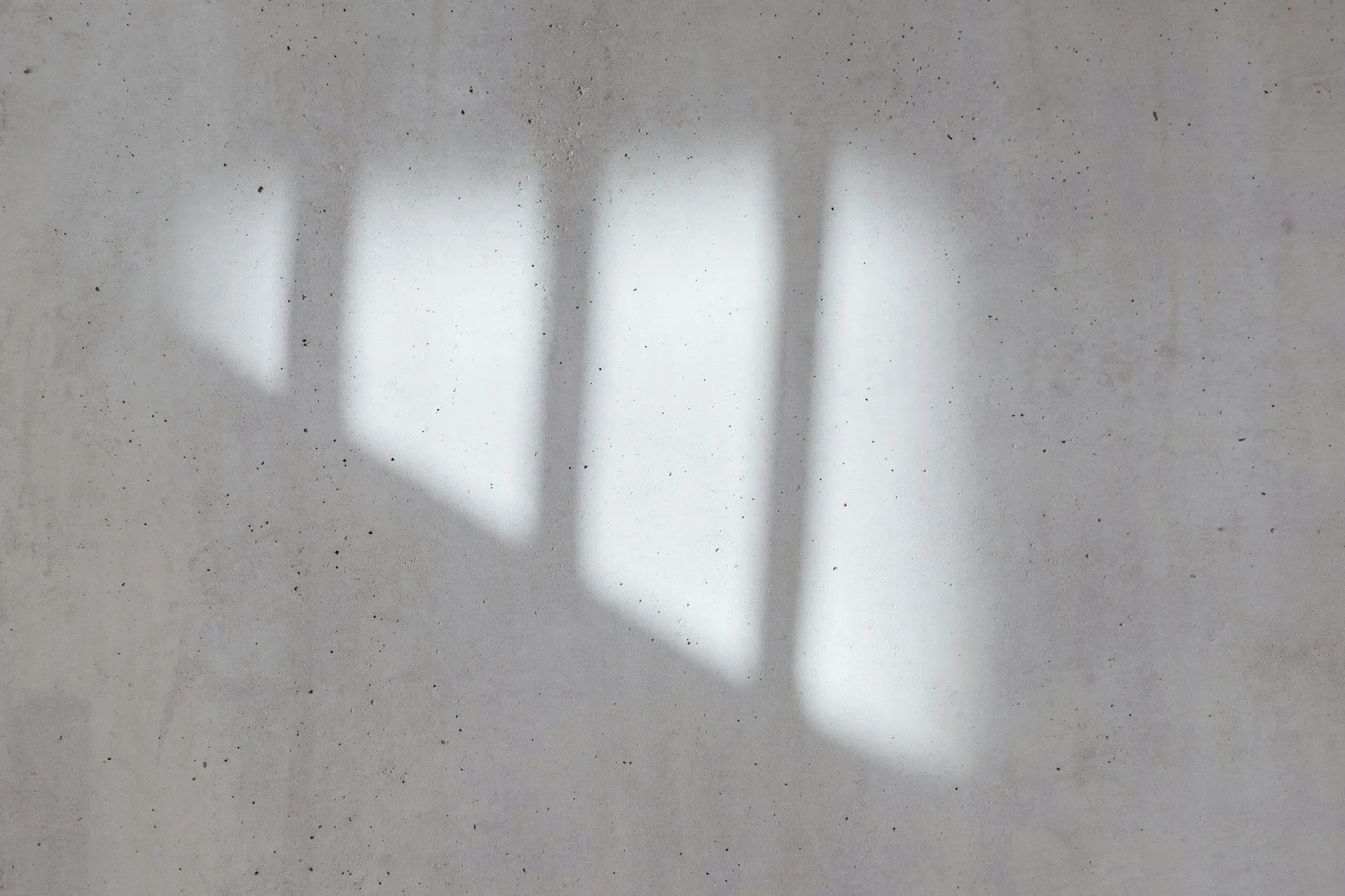 Smooth wall surface with soft window shadows creating a subtle pattern.