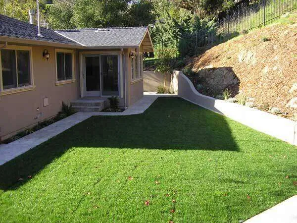 Stucco exterior of a single-family home with a lawn and concrete path in Greenbrae. — work near Greenbrae