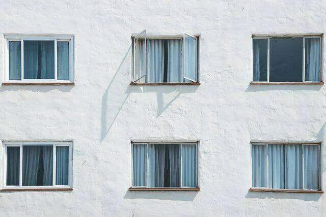 White stucco exterior wall with several windows, some open, showing a textured finish. — work near Healdsburg