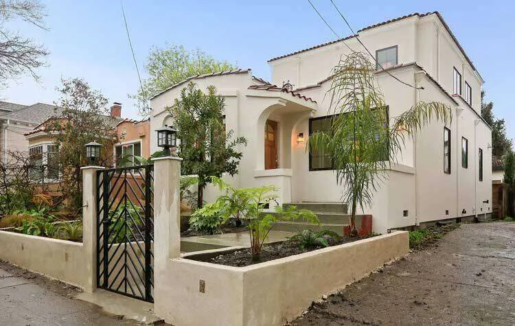 Two-story stucco home with gated entrance and landscaped yard in Oakland. — Oakland area