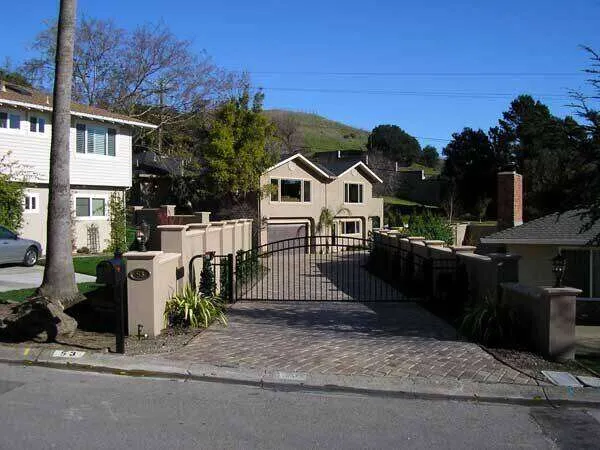 Stucco home in Greenbrae with a gated driveway and landscaped surroundings. — Larkspur area