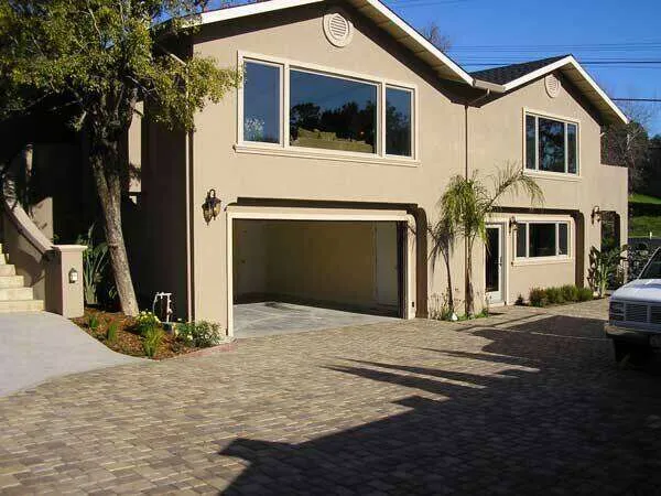 Two-story stucco home with large windows and paved driveway in Greenbrae. — Corte Madera area