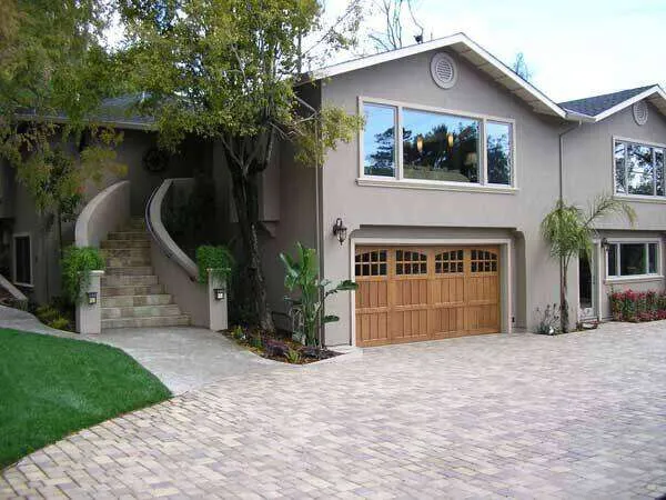 Two-story stucco home with wooden garage door and curved staircase in Greenbrae. — Greenbrae area