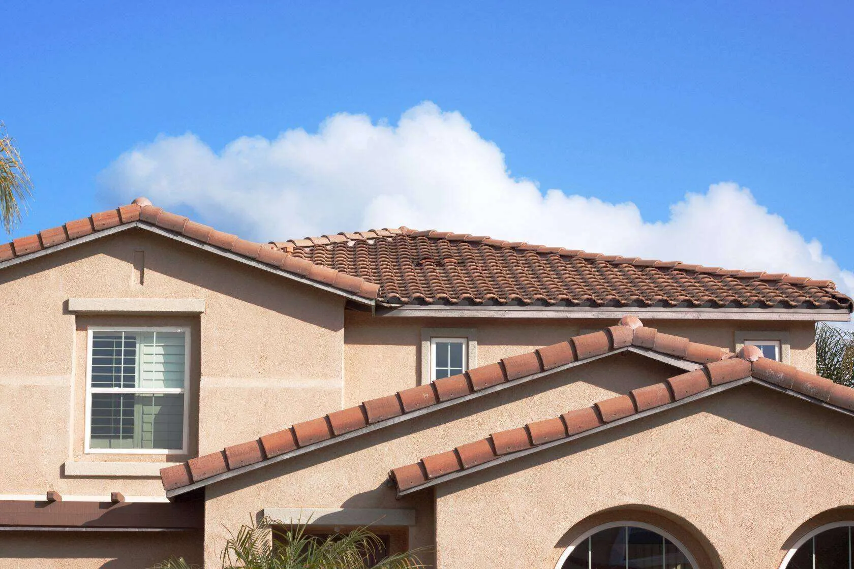 Stucco house with red tile roof and window under a clear blue sky. — Pinole area