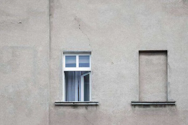 Stucco wall with visible cracks, an open window, and a sealed window space. — Tiburon area