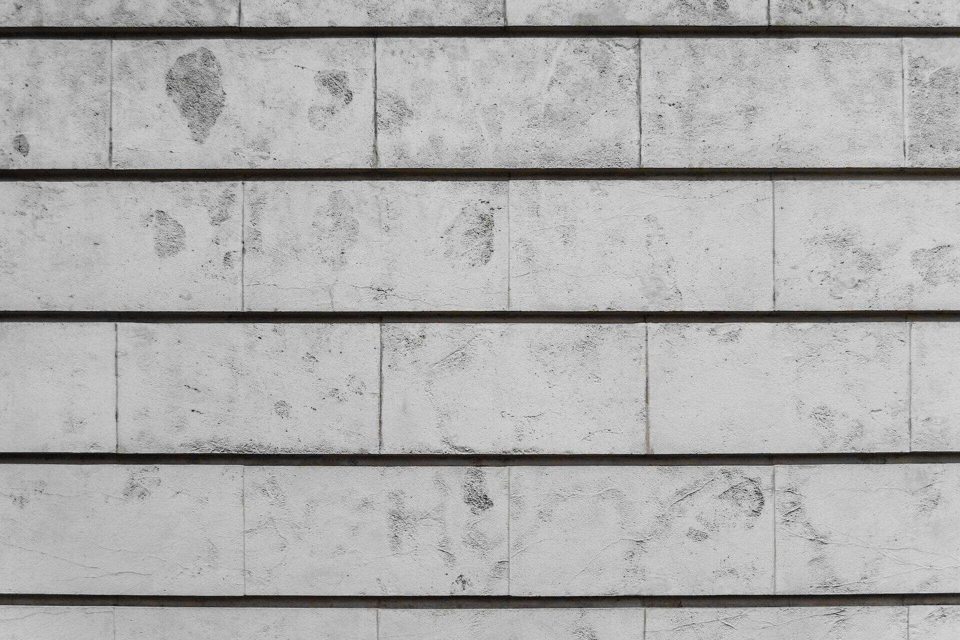 Close-up of a textured concrete wall with horizontal lines and visible marks.