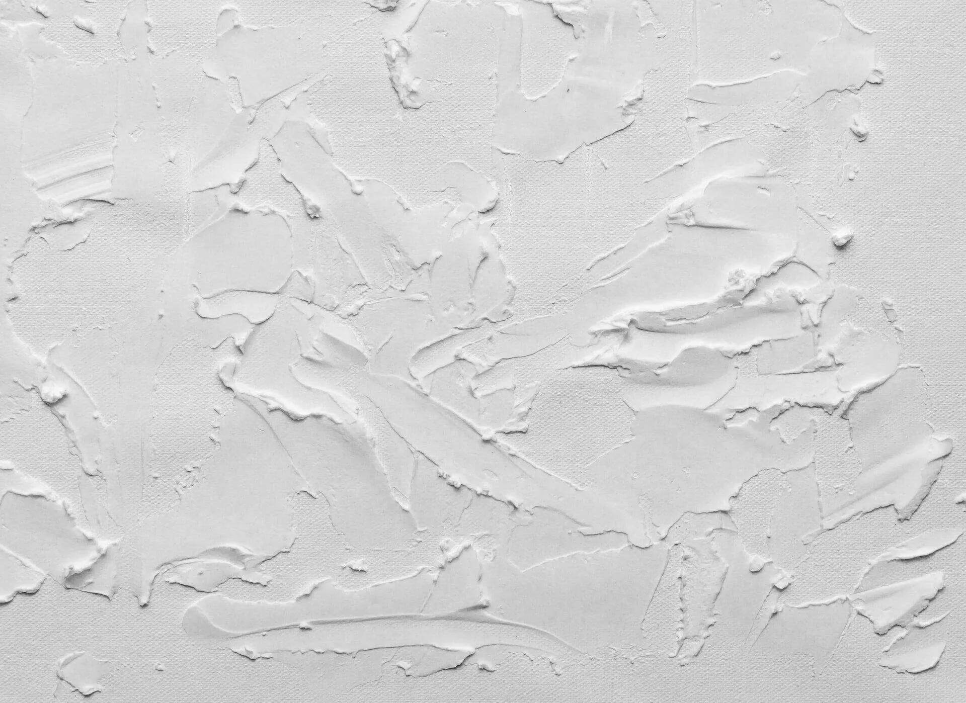 Close-up of a white textured plaster surface with visible trowel marks.