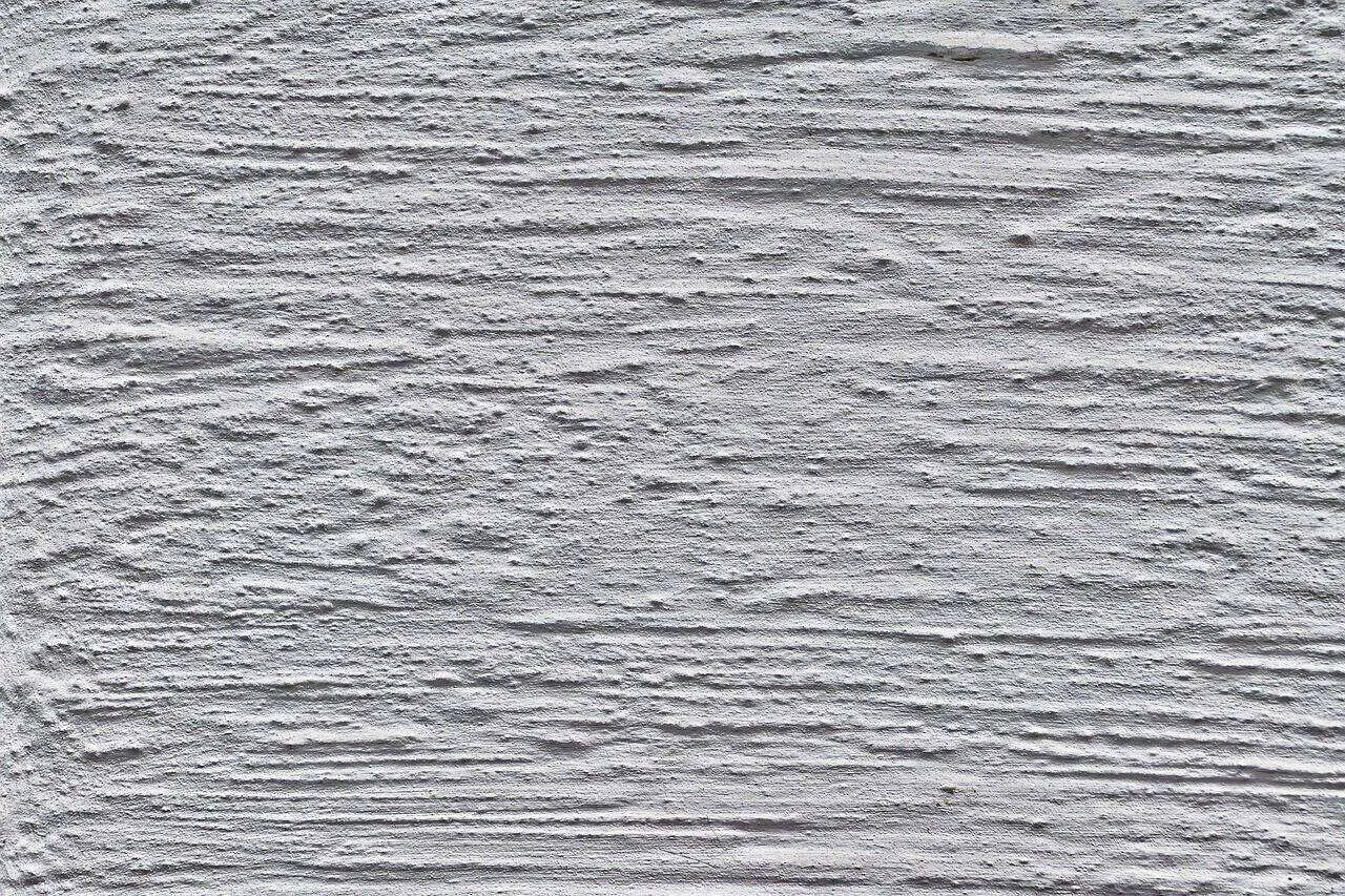 Close-up of a textured plaster wall with horizontal ridges and grooves.