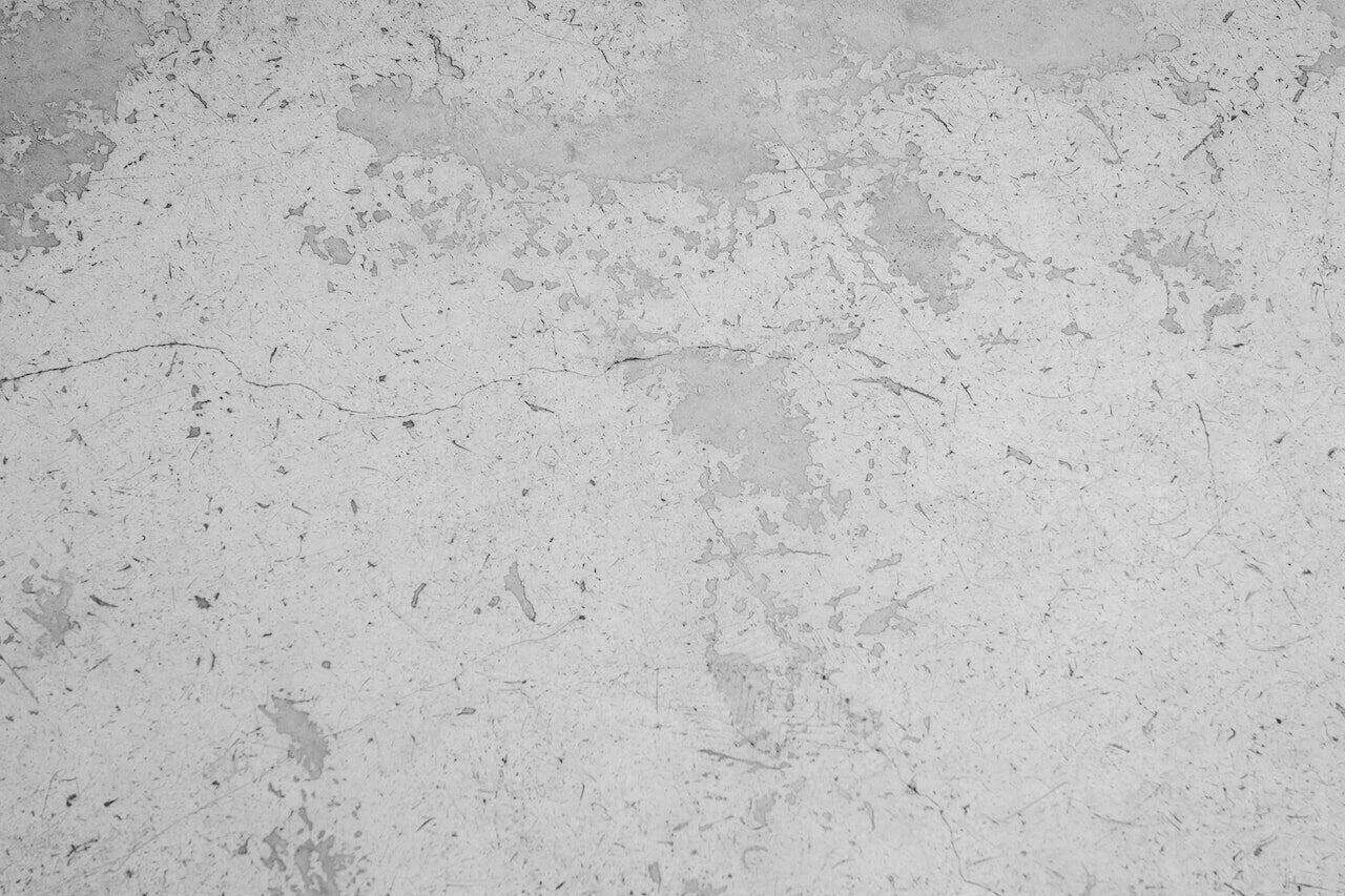 Close-up of a textured plaster wall with visible cracks and color variations.