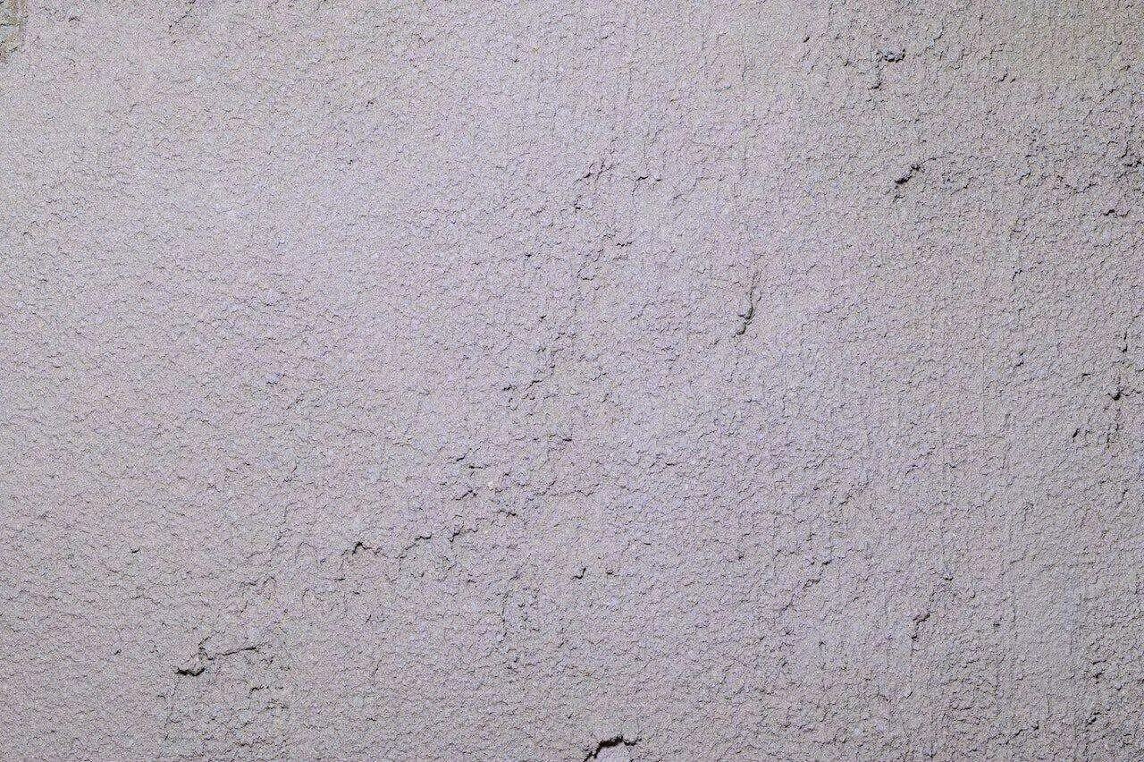 Close-up view of a textured wall surface with a rough plaster finish.