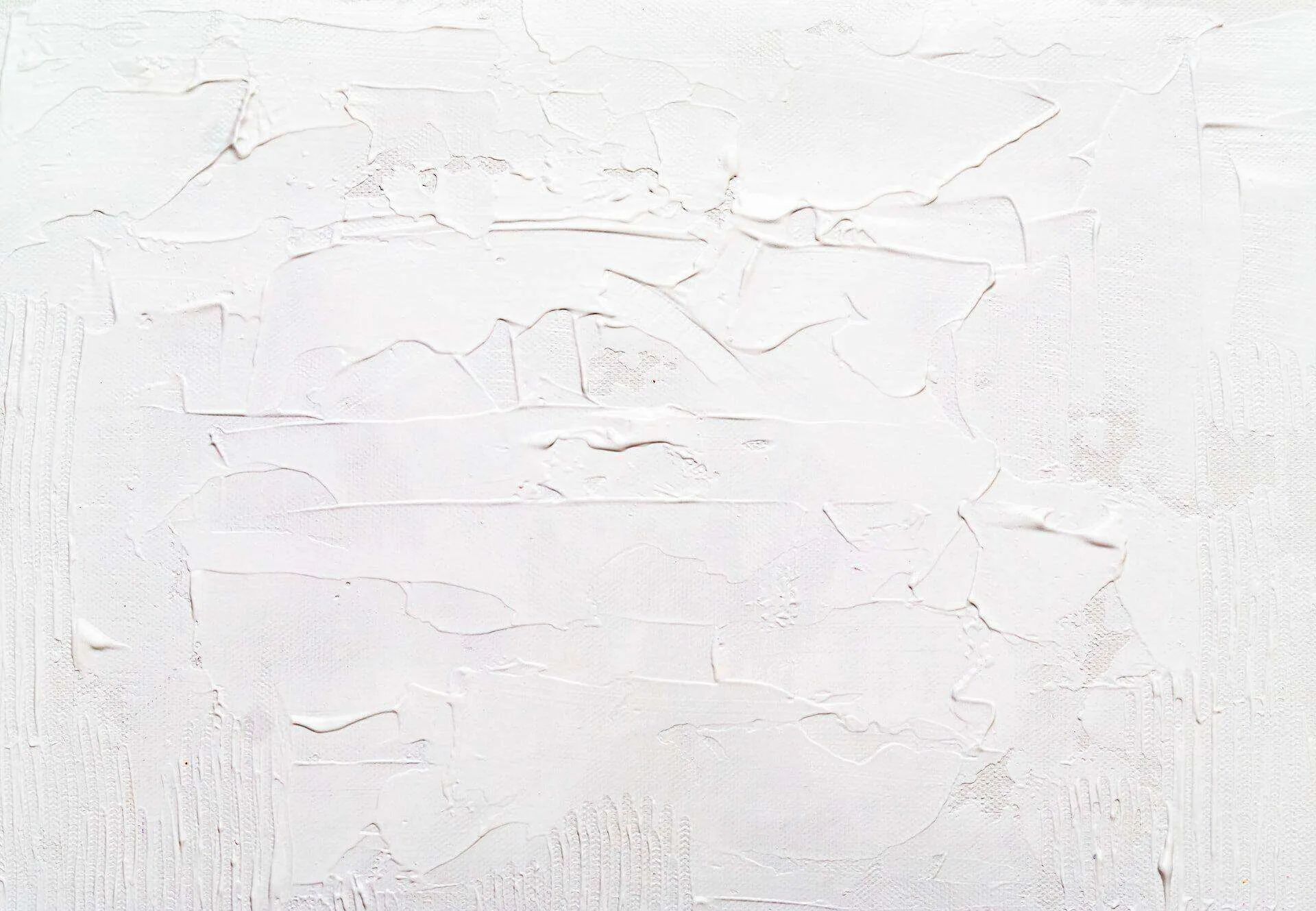 Close-up of a textured white plaster surface with visible trowel marks.
