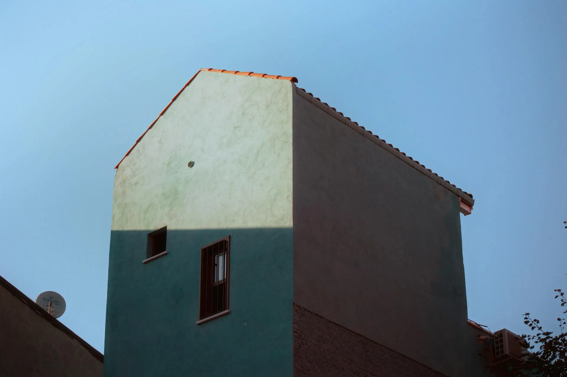 Building with two-tone smooth plaster finish under clear sky. — Kensington area